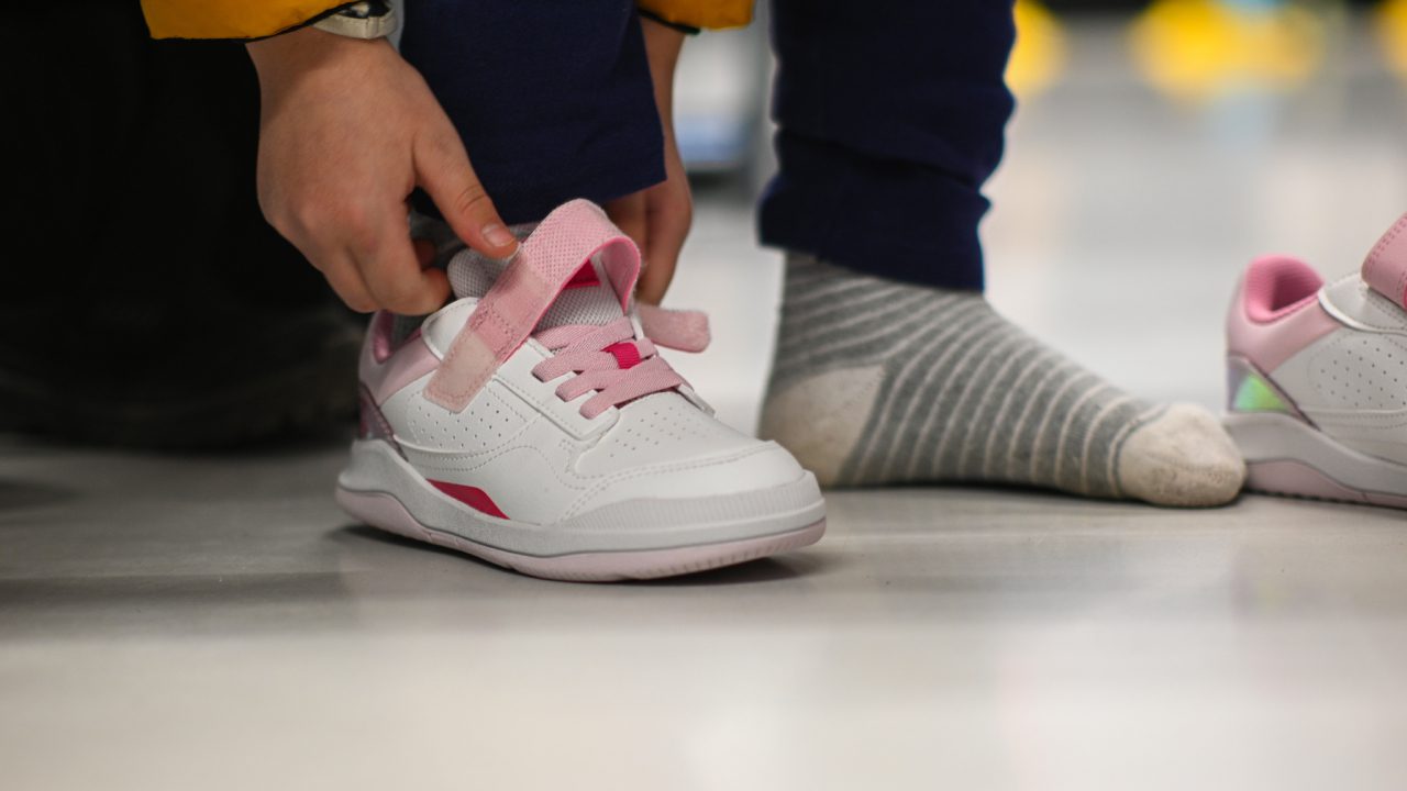A person tying their shoe on the ground